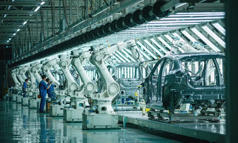 Robotic arms on an electric vehicle assembly line